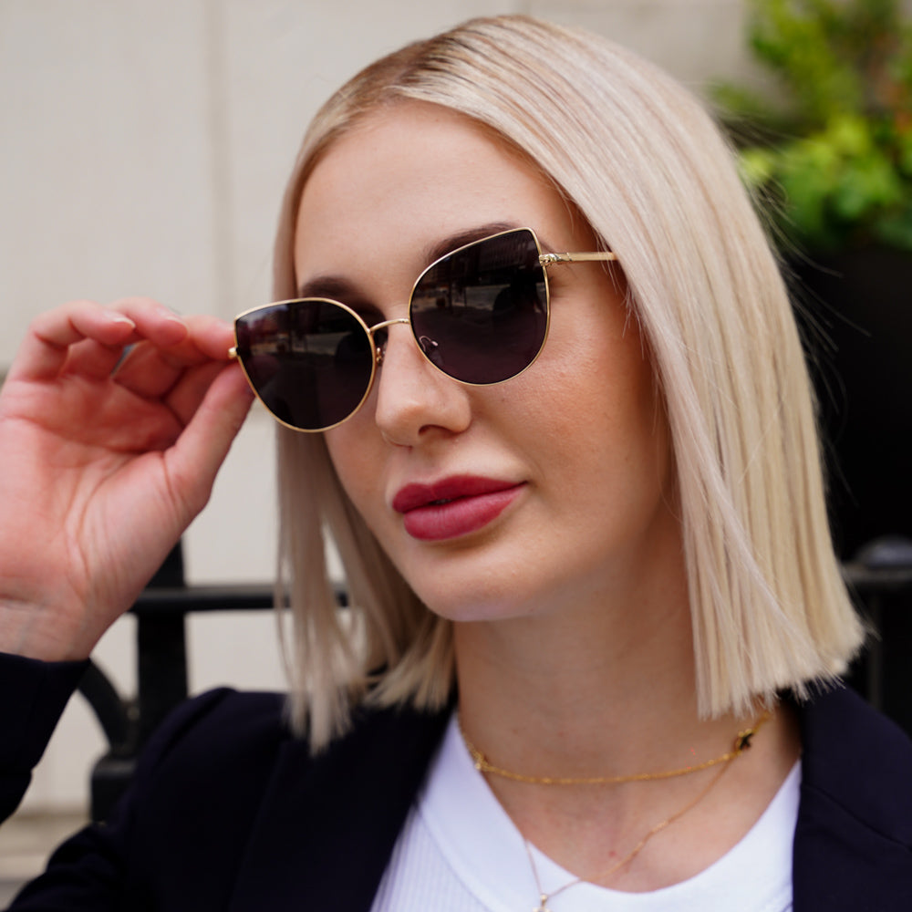 @jasmine.pring wearing Glamour Glasses Lexi Sunglasses featuring a thin golden cat eye frame - looking away profile shot